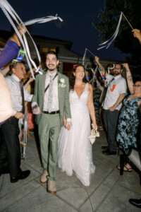 Bride and groom walk to getaway car after reception at Saphire Estate