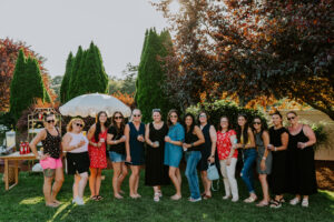 Staff poses in front of a cocktail station in The Tent's gardens.