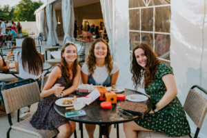 staff sitting in front of The Tent, eating food from the food trucks