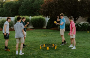 staff plays Spikeball in The Tent's garden area